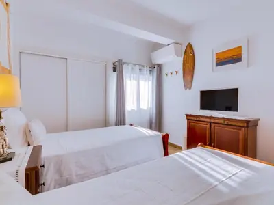a hotel room with two beds and a television at Noah House, 2 bdr apartment with sea view in Quarteira