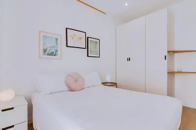 a white bedroom with a large white bed at Apartment with Rooftop and work space in Quarteira in Quarteira