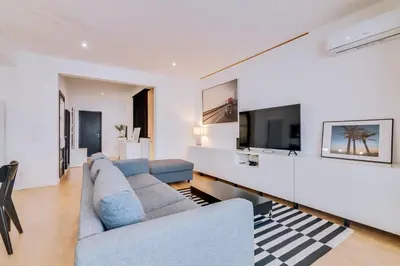 a living room with a couch and a tv at Apartment with Rooftop and work space in Quarteira in Quarteira
