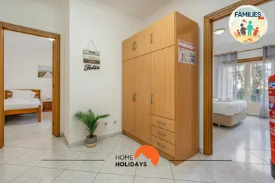 a bedroom with a large wooden cabinet and a bed at #230 Only Families - Flat A Flor by Home Holidays in Albufeira