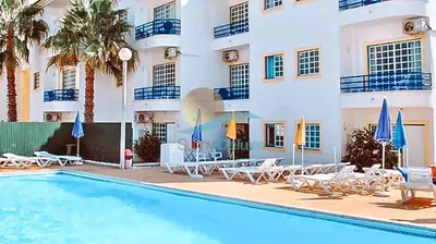 a hotel with a swimming pool in front of a building at Sereia da Oura by Sunny Deluxe in Vale de Pedras