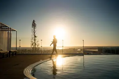 a man and a woman sitting next to a pool at Castelo Suites Hotel in Albufeira