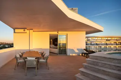 a living room with a white couch and a table at Castelo Suites Hotel in Albufeira