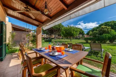 a wooden table and chairs on a patio at Vilamouratenis Monet by SAPvillas in Vilamoura