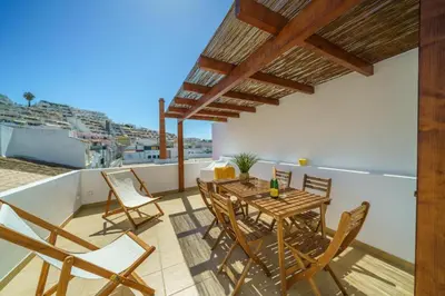 a patio with a table and chairs on a balcony at Oldtown Starfish Beach House 2 min to the beach Wifi in Albufeira