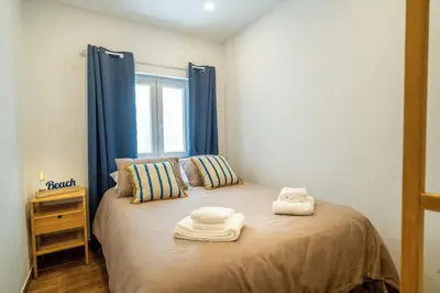 a bedroom with a bed with towels on it at Oldtown Starfish Beach House 2 min to the beach Wifi in Albufeira