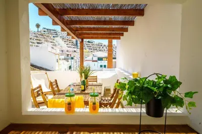 a patio with a table and chairs on a balcony at Oldtown Starfish Beach House 2 min to the beach Wifi in Albufeira