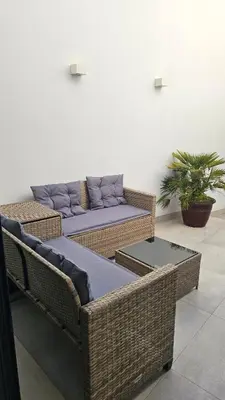 two wicker chairs and a couch in a room at City Center Villa in Faro