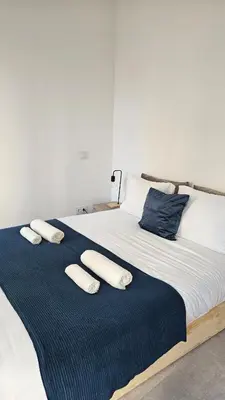 a bed with three pillows on top of it at City Center Villa in Faro