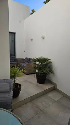 a patio with two potted plants and a couch at City Center Villa in Faro
