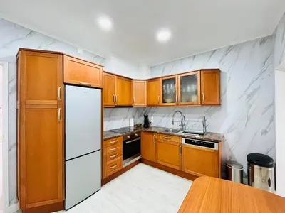 a kitchen with wooden cabinets and a white refrigerator at BrisaMarVilas Sea view, 5 min Walk to Town & Beach in Albufeira