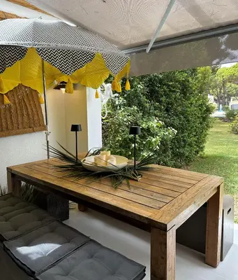 a wooden table sitting on a patio with at Vilamouratenis White by SAPvillas in Vilamoura