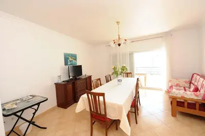 a kitchen and dining room with a table and chairs at Appartement Quarteira in Quarteira