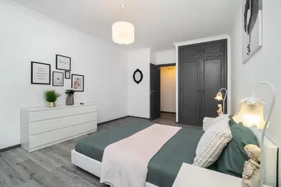 a white bedroom with a bed and a dresser at Vilamoura Family Escape in Quarteira