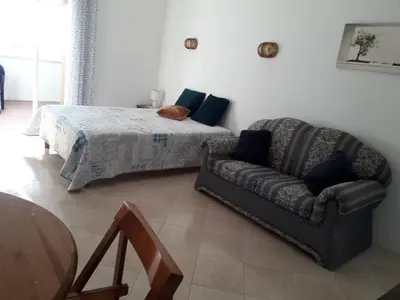 a bedroom with a bed and a couch at Quarteira Azul in Quarteira
