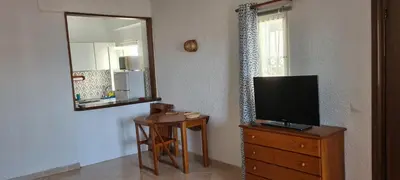 a room with a television on a dresser with a mirror at Quarteira Azul in Quarteira