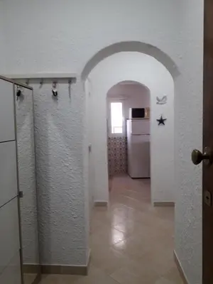 a hallway with a white wall and a refrigerator at Quarteira Azul in Quarteira