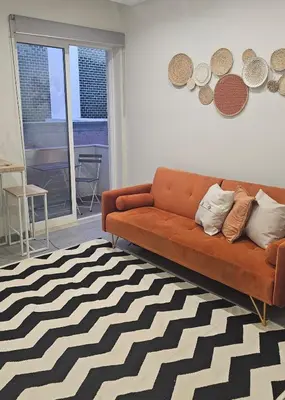 a living room with a orange couch and a black and white rug at Oldtown Nightlife in Faro