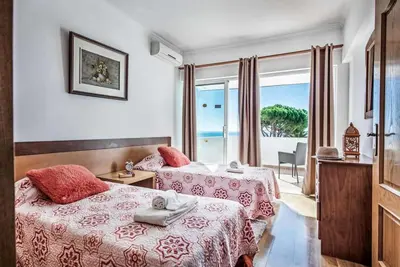 a hotel room with two beds and a view of the ocean at Atlantic Sul in Albufeira