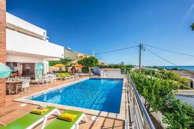 a swimming pool with tables and chairs on a patio at Atlantic Sul in Albufeira