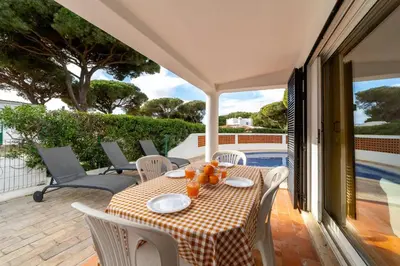 a table and chairs on the patio of a house at Villa Uno by HelloVacations in Loulé