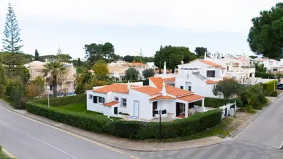a white house with an orange roof on a street at Villa Uno by HelloVacations in Loulé