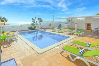 a swimming pool with tables and chairs and a patio at Casa Sol in Albufeira