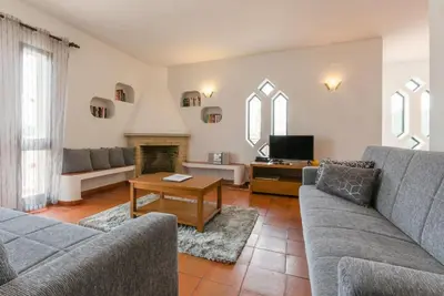 a living room with two couches and a tv at Villa Praia in Albufeira