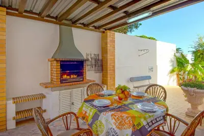 a table and chairs with a fireplace on a patio at Villa Mar in Albufeira