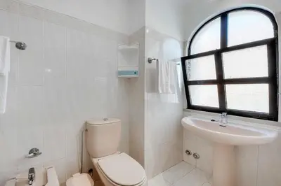 a white bathroom with a toilet and a sink at Villa Mar in Albufeira