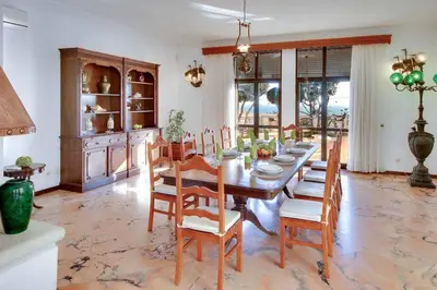 a dining room with a wooden table and chairs at Villa Mar in Albufeira