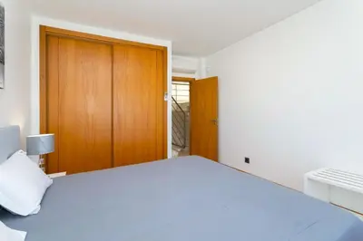 a bedroom with a bed and a wooden door at Stunning Villa with Heated Pool, Garden, BBQ in Quarteira