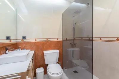 a bathroom with a toilet and a shower and a sink at Stunning Villa with Heated Pool, Garden, BBQ in Quarteira