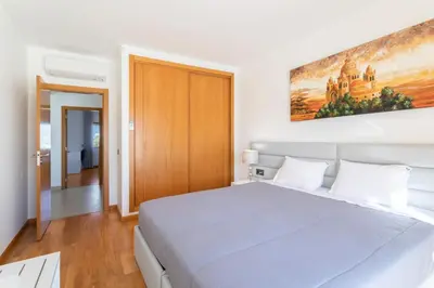 a bedroom with a large bed and a painting on the wall at Stunning Villa with Heated Pool, Garden, BBQ in Quarteira