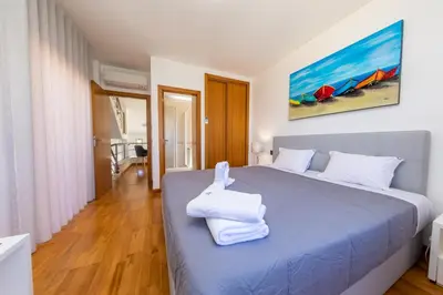 a bedroom with a large blue bed with white towels on it at Stunning Villa with Heated Pool, Garden, BBQ in Quarteira