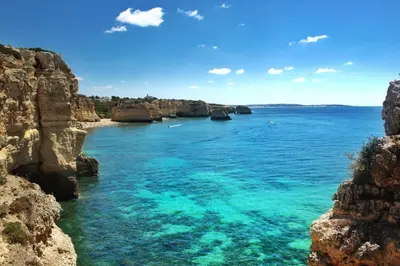 a view of the ocean between two rocky cliffs at Stunning Villa with Heated Pool, Garden, BBQ in Quarteira