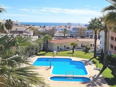 a swimming pool in a yard with palm trees at Albufeira Central Studio w swim pool and Seaview in Albufeira