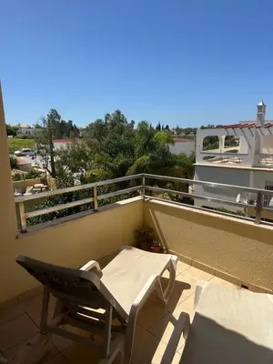 a balcony with a table and chairs on a roof at Jardins da guia in Albufeira