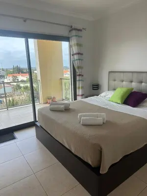 a bedroom with a large bed with two towels on it at Jardins da guia in Albufeira