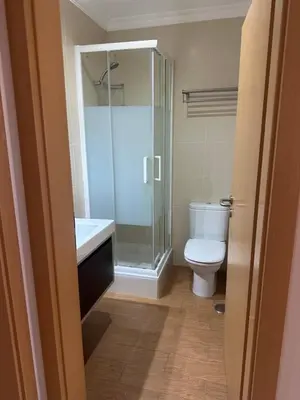 a bathroom with a toilet and a glass shower at Jardins da guia in Albufeira