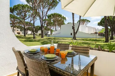a glass table with chairs and orange juice on it at Vilamouratenis Sunscape by SAPvillas in Vilamoura