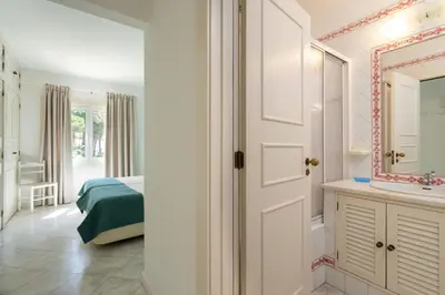 a bedroom with a bed and a sink and a mirror at Vilamouratenis Sunscape by SAPvillas in Vilamoura