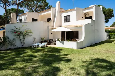 a white house with a lawn in front of it at Vilamouratenis Sunscape by SAPvillas in Vilamoura
