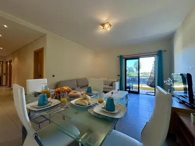 a dining room with a glass table and chairs at Quarteira Stylish 3 with Pool by Homing in Quarteira