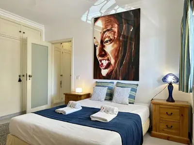 a bedroom with a bed with a painting on the wall at Vilamoura Grand Terrace with Pool by Homing in Vilamoura