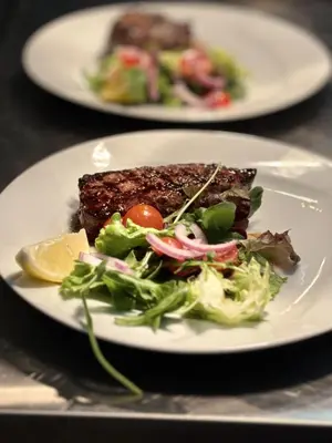 a plate of food with a salad and steak at Vilamoura Grand Terrace with Pool by Homing in Vilamoura