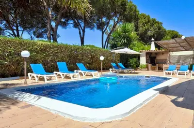 a swimming pool with blue lounge chairs and a pool at Villa Atlantico in Quarteira