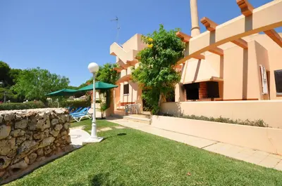 a house with a yard with a stone wall at Villa Gardenia in Quarteira