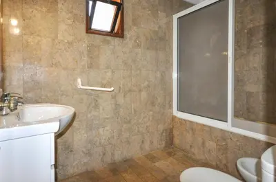 a bathroom with a sink and a toilet and a window at Villa Gardenia in Quarteira