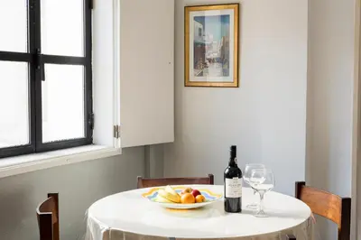 a table with a bottle of wine and a bowl of fruit at LUIS - Vilamoura in Vilamoura